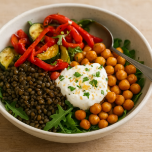 Bowl de lentilles du Puy avec pois chiches rôtis, légumes rôtis et sauce yaourt citronnée, garni de persil et graines de sésame